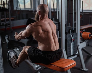 Kürek çekme makinesinde kürek çeken beyaz bir adam.