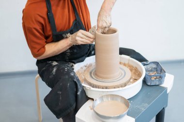 Çömlekçi elleriyle çömlekçi çarkında seramik vazo yaparken.