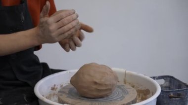 A potter kneads clay before using it in the workshop. Close-up of a mans hands