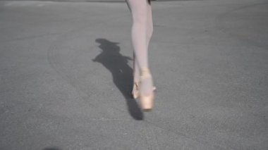 Balerin dışarıda dans ediyor. Sivri uçlu ayakkabılı bir kadının bacaklarının yakın çekimi. Dikey video