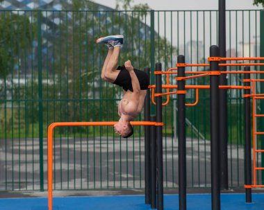 Açık hava sporlarında ters takla atan genç bir erkek sporcu.