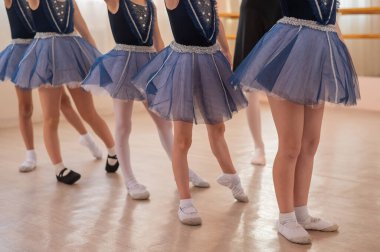 Çocuk bale okulu. Beş küçük balerin ve koreograflarının ayaklarına yakın çekim.