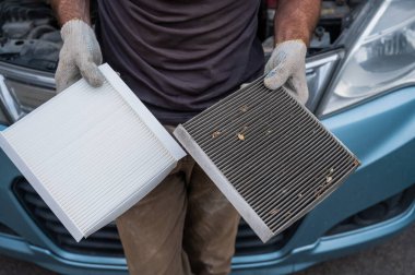 Usta arabanın kabin hava filtresini değiştiriyor.