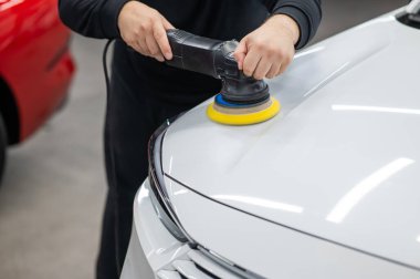 Yörüngesel cilalama makinesi kullanılarak beyaz arabanın kaput yüzeyinin parlatılması işlemi