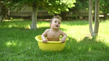 Tatlı erkek bebek yazın havuzda yıkanır.