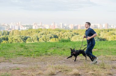 Pitbull teriyeriyle koşan bir adam.