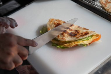 Aşçı somonla yassı ekmeği keser