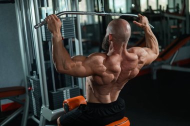 Kafkasyalı bir adam bir makinede çekiş yapıyor.