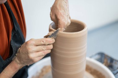 Çömlekçi elleriyle çömlekçi çarkında seramik vazo yaparken.