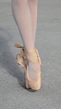 Balerin dışarıda dans ediyor. Sivri uçlu ayakkabılı bir kadının bacaklarının yakın çekimi. Dikey video