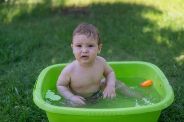 Mutsuz çocuk yazın havuzda yıkanır.