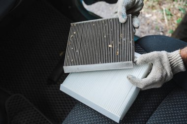 Usta arabanın kabin hava filtresini değiştiriyor.