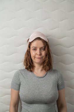 Mutsuz bir kadının uyku maskesini çıkarmasının ve uykusuzluk çekmesinin en iyi görüntüsü. Dikey fotoğraf