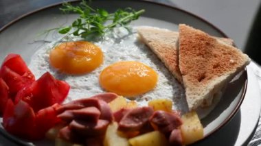 Bir kafede İngiliz kahvaltısı rezervasyonu. Yuvarlak bir masada yumurtalı bir tabak döner.