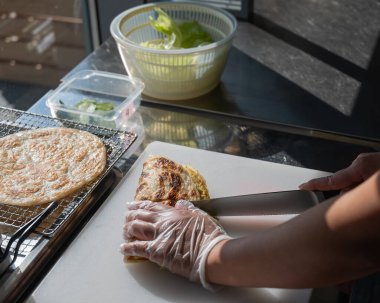 Aşçı somonla yassı ekmeği keser. Quesadilla