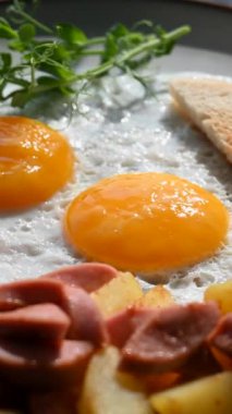 Bir kafede İngiliz kahvaltısı rezervasyonu. Yuvarlak bir masada yumurtalı bir tabak döner. Dikey video