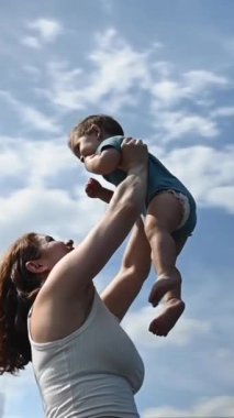 Kafkasyalı kadın bir yaşındaki oğlunu başının üstünde tutuyordu. 360 derece dikey video