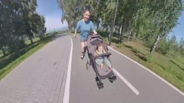 Beyaz kadın, oğluyla bebek arabasında paten kayıyor.