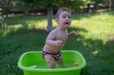 Mutsuz çocuk yazın havuzda yıkanır.