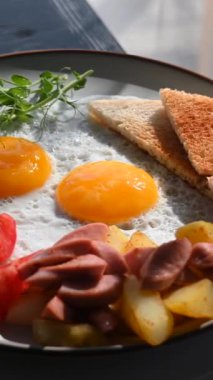 Bir kafede İngiliz kahvaltısı rezervasyonu. Yuvarlak bir masada yumurtalı bir tabak döner. Dikey video