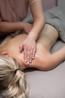 Rahim boynu bölgesinde masaj yaptıran bir kadın. Dikey fotoğraf