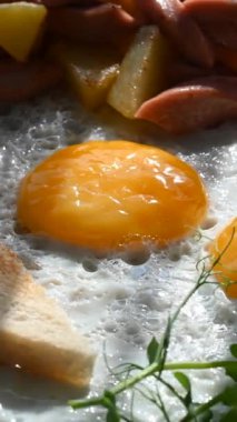 Bir kafede İngiliz kahvaltısı rezervasyonu. Yuvarlak bir masada yumurtalı bir tabak döner. Dikey video