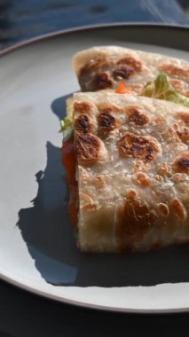 Balık ve peynirle doldurulmuş bir yassı ekmek yuvarlak bir masada döner. Quesadilla. Dikey video