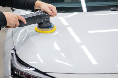 Yörüngesel cilalama makinesi kullanılarak beyaz arabanın kaput yüzeyinin parlatılması işlemi