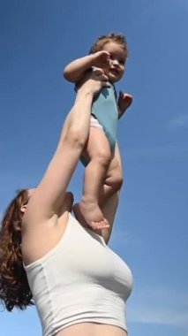 Kafkasyalı kadın bir yaşındaki oğlunu başının üstünde tutuyordu. 360 derece dikey video