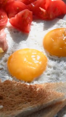 Bir kafede İngiliz kahvaltısı rezervasyonu. Yuvarlak bir masada yumurtalı bir tabak döner. Dikey video