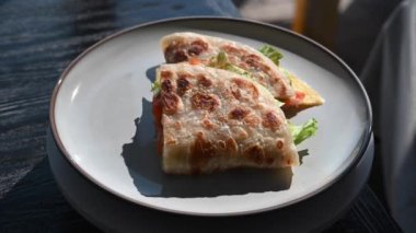 Balık ve peynirle doldurulmuş bir yassı ekmek yuvarlak bir masada döner. Quesadilla