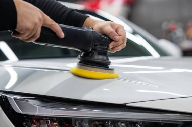 Yörüngesel cilalama makinesi kullanılarak beyaz arabanın kaput yüzeyinin parlatılması işlemi
