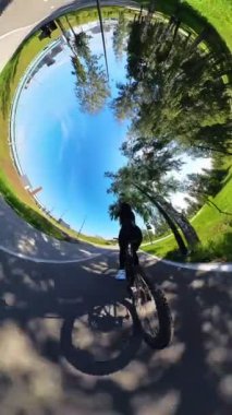 Beyaz bir kadın oturur ve bisiklete biner. 360 derecelik video