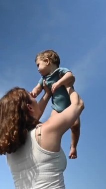 Kafkasyalı kadın bir yaşındaki oğlunu başının üstünde tutuyordu. 360 derece dikey video