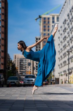 Dışarıda dans eden güzel bir Asyalı balerin. Şehir manzarası