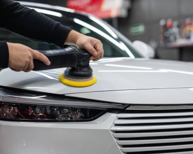 Yörüngesel cilalama makinesi kullanılarak beyaz arabanın kaput yüzeyinin parlatılması işlemi