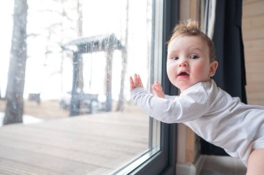 Bebek çocuk verandanın önünde duruyor.