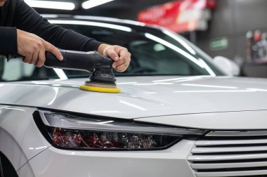 Yörüngesel cilalama makinesi kullanılarak beyaz arabanın kaput yüzeyinin parlatılması işlemi