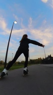 Akşamları paten kayan beyaz kadın. Slalom. Dikey video