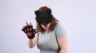 Beyaz arka planda kedi kostümü giymiş bir kadının portresi. Kuadrober