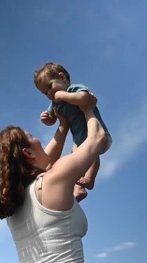 Kafkasyalı kadın bir yaşındaki oğlunu başının üstünde tutuyordu. 360 derece dikey video