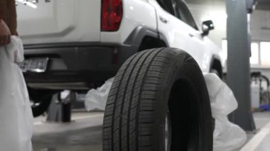 Tamirci garajda eski lastikleri topluyor.