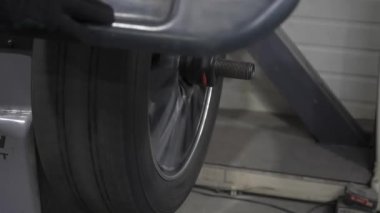 Tamirci atölyede tekerleği dengeliyor.