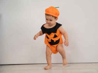 Cadılar Bayramı için balkabağı kostümü giymiş beyaz tatlı bir çocuk.