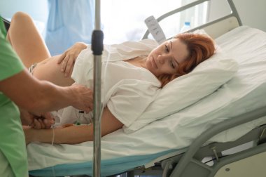 Beyaz kadın hastanede doğum yapıyor.