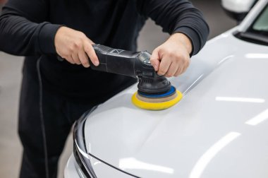 Yörüngesel cilalama makinesi kullanılarak beyaz arabanın kaput yüzeyinin parlatılması işlemi