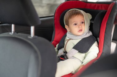 Araba koltuğunda beyaz bir çocuk var.