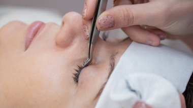 Bir usta bir istemciden kirpik uzantılarını kaldırır