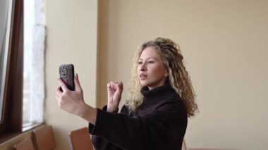 Beyaz kadın video bağlantısıyla İngilizce işaret dili öğretiyor.