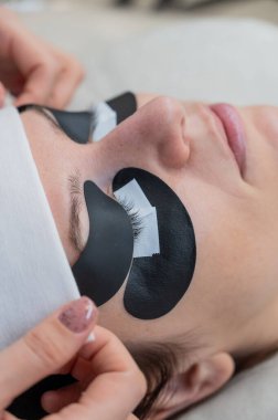 Efendi, LED kirpik uzantılarından önce ultraviyole ışınların içeri girmesine izin vermeyen koruyucu yamalar uyguluyor